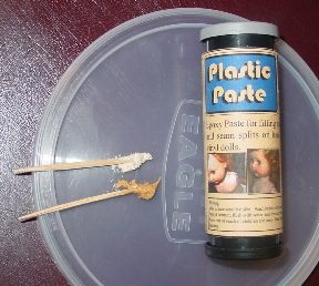 Plastic paste with two wooden sticks on a plastic lid.